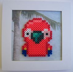 a beaded picture of a red bird with sunglasses on it's face and palm tree in the background