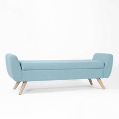 an upholstered bench with wooden legs and a light blue fabric cover on it