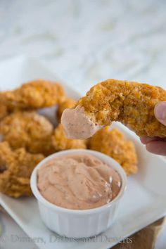 a person is dipping sauce on some fried food