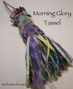 a close up of a piece of cloth on a white surface with the words morning glory tassel written above it