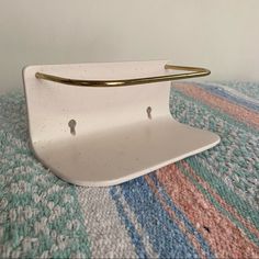 a white tray with two gold handles sitting on top of a colorful carpeted area