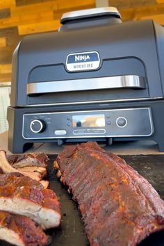 the ribs are being cooked on the grill in front of an electric smoker oven