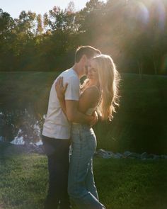 a man and woman standing next to each other in the grass