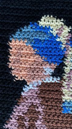 a crocheted blanket with different colors and shapes on the bottom, along with an image of a woman's face