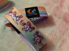 "Double sided elastic fabric wristbands. One side Sweetiee the Sylveon pokesona, and the other side pastel rainbow to show off some love!  - One size fits most (but about 7\") - Printed elastic - Embroidered logo (of artist company Show&Tail)" Artist Logo, Elastic Fabric, Wristbands, Braided Bracelets, Pastel Rainbow, The Other Side, Sunglasses Case, Double Sided, Etsy Accessories