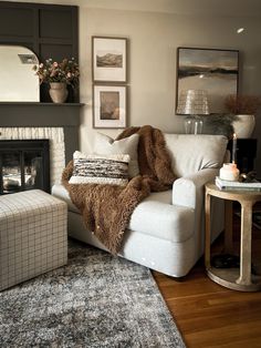 a living room filled with furniture and a fire place next to a rug on top of a hard wood floor