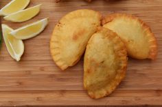 some food is laying out on a cutting board with lemon wedges next to it