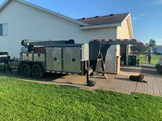 a dog laying on the ground in front of a house with a trailer attached to it