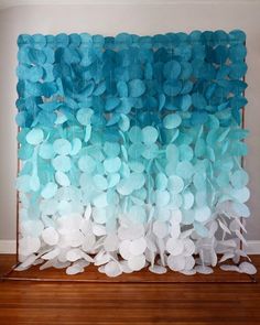 a large blue and white curtain with circles on the bottom, in front of a wooden floor