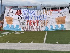 a banner on the sidelines at a football game that reads, all hands on deck to overthrow the pirate ship against atlantics