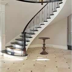 a spiral staircase in a home with tiled flooring and white walls on either side