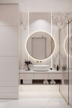 a bathroom with marble walls and flooring, round mirror on the wall above the sink