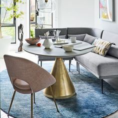 a living room filled with lots of furniture next to a dining table and couches