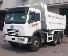 a white dump truck parked in front of a building