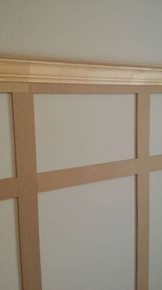 an empty room with white walls and wood trimmings on the door, which has been painted light brown