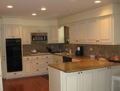 a kitchen with white cabinets and granite counter tops