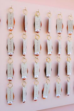 a pink wall with lots of different types of key chains hanging on it's sides