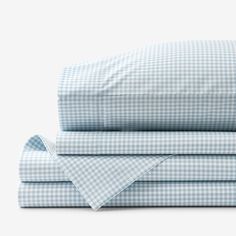 the sheets and pillowcases are folded on top of each other in blue gingham