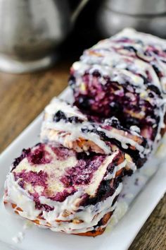 blueberry roll on a plate with icing drizzled over it's edges