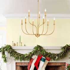 a fireplace decorated for christmas with stockings hanging from the mantel and candles on top