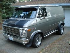 an old gray van parked in front of a house