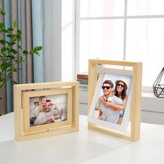 two wooden frames with photos on them sitting on a table