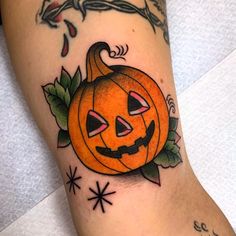 a tattoo with a pumpkin and leaves on it