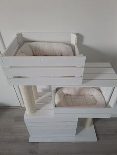 a white cat tree with two cats in it's cages on top of each other