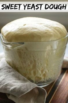 a loaf of bread sitting in a glass bowl on top of a wooden cutting board