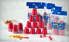 red plastic cups and dices sitting on a table next to bags of candy canes