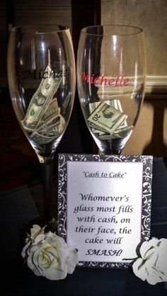 two wine glasses sitting on top of a table with money in the glass next to it