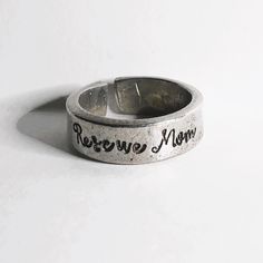 This silver pewter Rescue Mom ring fits size 9 - 9 1/2.   🔨I form each ring by hand and each letter is individually stamped. Handcrafting each ring and individually stamping each letter adds a personal touch.  The slight variations in letter spacing and depth are a testament to the authenticity of hand-stamped items, making each piece uniquely yours. ➡️Pewter rings, known for their soft, silvery-gray color, have a pleasant weight to them, making them feel substantial yet comfortable to wear. Your ring will arrive in a small, brown kraft box or organza bag for storage or gifting. 🫧Caring for Your Pewter Jewelry🫧 🫧To Clean Moisten a soft cloth with water and wring it out so that the cloth so it is just damp. Apply a small dot of hand soap to the cloth and work the soap into light bubbles Artisan Stamped Rings As Collectibles, Everyday Hand Stamped Silver Rings, Western Stamped Rings, Silver Antique Stamped Rings, Western Metal Stamped Rings, Letter Spacing, Pewter Ring, Pewter Jewelry, Mom Ring