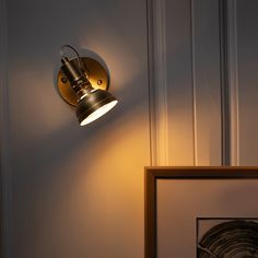 a light that is on the wall next to a framed photo and some lights in front of it