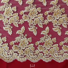 an embroidered red fabric with gold and white flowers on the side, in front of a red background