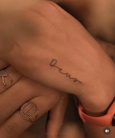 two hands holding each other with the word love tattooed on them