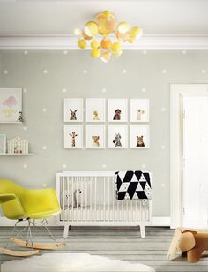 a baby's room with a rocking chair, crib and pictures on the wall