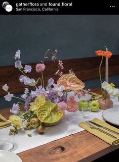 the table is set with flowers and plates