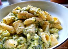 a white bowl filled with pasta and broccoli