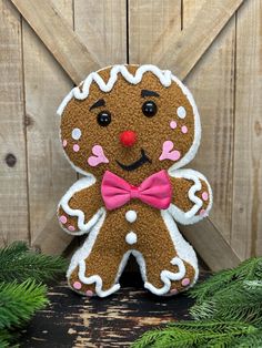 a close up of a stuffed animal on a wooden surface with fir branches and pine needles