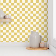 a yellow and white checkered wallpaper in a kitchen with two vases on the counter