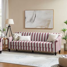 a living room filled with furniture and a large painting hanging on the wall above it