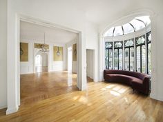 an empty living room with wood floors and large arched windows on either side of the wall