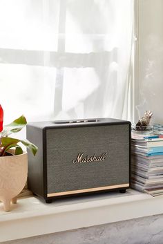 a radio sitting on top of a window sill next to a potted plant