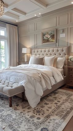 a large bed sitting in the middle of a bedroom next to a window with a chandelier