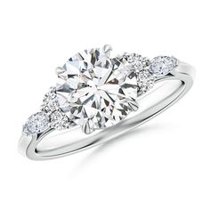 a three stone engagement ring with diamonds on the shoulders and side stones in white gold