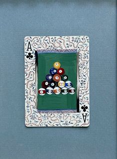 a pool table with eight balles in the middle and two cards on top, framed against a blue wall