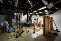 a man standing in front of a camera on top of a hard wood floor next to other equipment