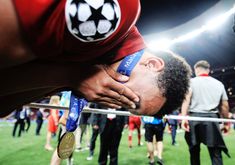 a man is holding onto his medal while onlookers stand in the background