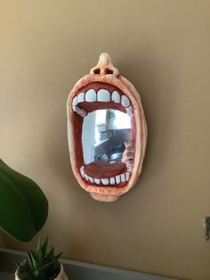 a mirror that is on the side of a wall with an open mouth in front of it