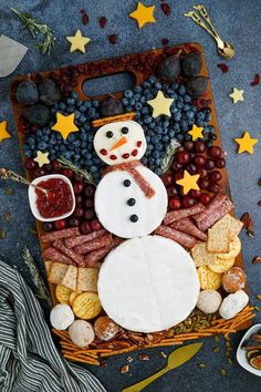 a snowman made out of cheese, crackers and grapes